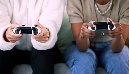 Image showing Woman, hands and friends gaming with controller on living room sofa in competitive match or game at home. Women playing video games in competition or esports sitting on lounge couch for entertainment