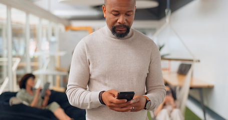 Image showing Businessman in office walking, typing on smartphone and greeting people at creative startup. Communication, technology and black man on walk at business checking phone for social media, email or text