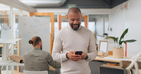 Image showing Businessman in office walking, typing on smartphone and greeting people at creative startup. Communication, technology and black man on walk at business checking phone for social media, email or text