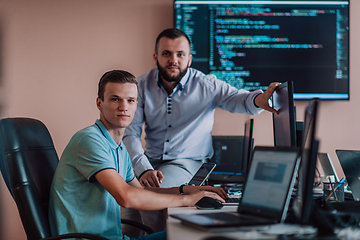 Image showing Programmers engrossed in deep collaboration, diligently working together to solve complex problems and develop innovative mobile applications with seamless functionality.