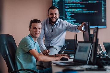 Image showing Programmers engrossed in deep collaboration, diligently working together to solve complex problems and develop innovative mobile applications with seamless functionality.