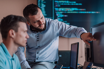 Image showing Programmers engrossed in deep collaboration, diligently working together to solve complex problems and develop innovative mobile applications with seamless functionality.