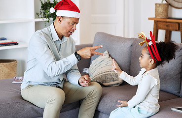 Image showing Senior family and kid play Christmas game together for fun, learning and bonding with numbers education. Grandfather or mature man talking and teaching girl child in lounge for thanksgiving holiday