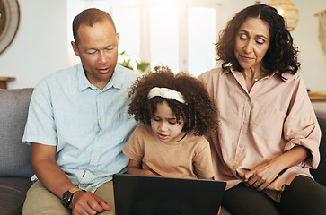 Image showing Child streaming a movie on laptop with her grandparents while relaxing on sofa in the living room. Technology, rest and girl watching video or film with grandfather and grandmother for entertainment.