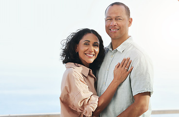 Image showing Portrait, smile and senior couple by beach, hug and enjoying quality time on holiday or vacation. Love, care and retired happy man and woman hugging, embrace or cuddle while having fun by ocean.