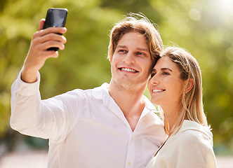 Image showing Couple, selfie and smile in park for love, care and happiness together in garden or nature for social media. Happy man, young woman and take photograph outdoor for holiday, date and relax in summer
