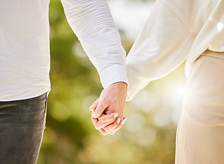 Image showing Couple holding hands in park for love, care and save the date marriage commitment together. Closeup hand of man, woman and walking in nature, garden and sunshine for relax, trust and support partner