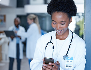 Image showing Black woman, doctor and smile with phone in hospital on telehealth app, internet search and connection. Happy medical worker typing on smartphone technology for contact, reading online chat or clinic