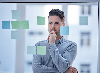 Image showing Creative man, thinking and brainstorming in schedule planning glass board for tasks or reminder at office. Male wondering in thought for project plan, idea or sticky note strategy for company startup