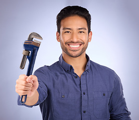 Image showing Man, smile and portrait with tools or wrench for handyman, maintenance or repair work in studio. Happy asian model person on purple background show spanner for engineer, mechanic or technician job