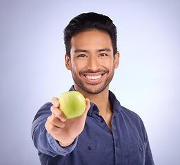 Image showing Portrait of happy man with apple isolated on studio background healthy diet, healthcare or nutritionist breakfast. Vegan person or asian model with green fruit or food for dietician care and choice