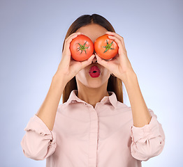 Image showing Woman, tomato and covering eyes in studio for healthy food, vegan diet and vegetable in hands. Face of a model person with red vegetables for health, wellness and skin care on purple background
