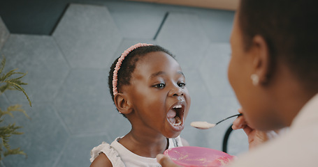 Image showing Mother, child and breakfast with mom feeding girl food for nutrition, growth health and wellness in home kitchen. Black woman with girl at family house for quality time, love and eating healthy