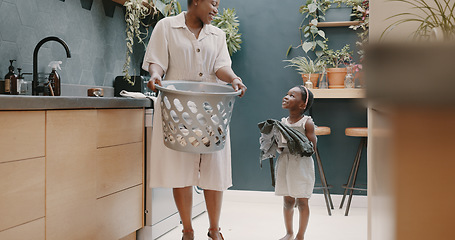 Image showing Laundry, mother and child helping with folding of clothes together in a house. Happy, excited and young girl giving help to her mom while cleaning clothing from a washing machine in their home