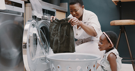 Image showing Laundry, mother and child helping with folding of clothes together in a house. Happy, excited and young girl giving help to her mom while cleaning clothing from a washing machine in their home