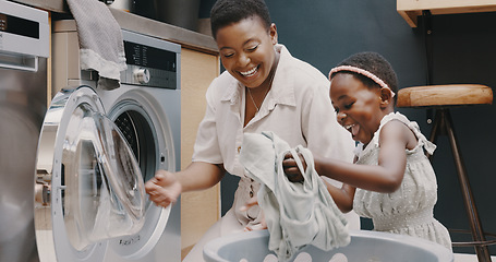 Image showing Laundry, mother and child helping with folding of clothes together in a house. Happy, excited and young girl giving help to her mom while cleaning clothing from a washing machine in their home