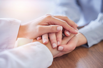 Image showing Holding hands, doctor and patient at desk for comfort, talking and communication for bad news, mental health or support. Therapist woman, cancer and together for empathy, care or wellness in hospital