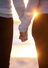 Image showing Back of couple holding hands at beach, sunset and vacation of save the date marriage. Closeup hand of man, woman and walking in sunshine, relax and trust of support, peace and love, travel or freedom