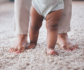 Image showing Baby feet, youth walking and kid learning with mother in living room lounge with mobility development. Floor, home and first steps of a young child with mama love, care and support in a house