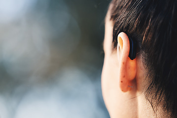 Image showing Woman, ear and hearing aid implant for disability with free space for mockup or advertising. Deaf person with medical device for listening to sound or audio with technology for wellness outdoor