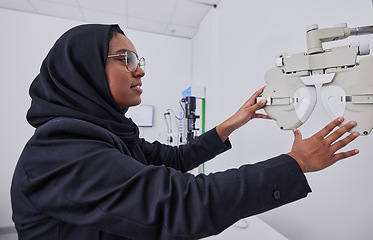 Image showing Optometry, vision and healthcare with an arabic woman at work in her eyecare office for testing. Hospital, medical or eye exam and a muslim female working with equipment for diagnosis at an optician