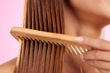 Image showing Beauty, comb and bamboo with hair of woman for health, salon and satisfaction in studio. Wellness, keratin and natural with girl model and self care for cosmetics, brush and shine on pink background