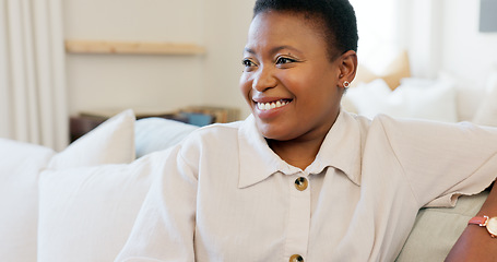 Image showing Happy, smile and black woman relaxing on a sofa while watching tv in the living room of her modern house. Happiness, laughing and African lady streaming a movie while sitting on a couch in her lounge
