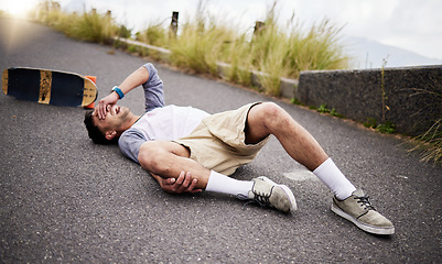 Image showing Accident, fall and knee injury with a skater man on the ground, lying down in pain after falling down. Sports, training and anatomy with a young male suffering a skateboard emergency outdoor