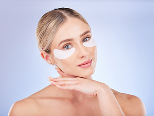 Image showing Face, skincare and woman with eye patches in studio isolated on a blue background. Dermatology portrait, cosmetics and beauty of female model with facial mask for healthy skin, anti aging or collagen