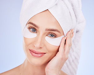 Image showing Skincare, face and woman with eye patches in studio isolated on a blue background. Dermatology portrait, beauty cosmetics and happy female model with towel and collagen facial mask for healthy skin.