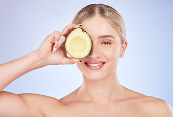 Image showing Skincare, face portrait and woman with avocado in studio isolated on a blue background. Cosmetics, fruit and happy female model holding food for omega 3, nutrition or diet, healthy skin or beauty.