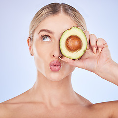 Image showing Skincare, face and woman with avocado in studio isolated on a blue background. Cosmetics kiss, fruit and thinking female model with food for omega 3, nutrition or diet, healthy skin or beauty pout.