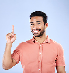 Image showing Happy, portrait and man pointing in a studio to mockup space for advertising, marketing or product placement. Happiness, smile and male model showing mock up while isolated by a purple background.