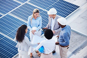 Image showing Solar and renewable energy, blueprint or engineering team on roof building electricity technology for sustainability. Collaboration, top view or black man talking or planning a project with people