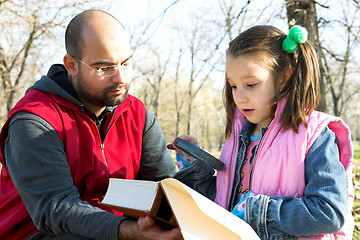 Image showing child and father reading the book