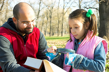 Image showing child and father reading the book