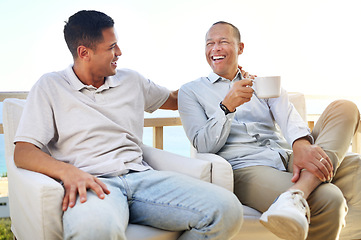 Image showing Laughing, talking and father and son with coffee, bonding and speaking during visit. Family, happy and dad with an adult man for communication about a funny story, conversation and tea on the balcony