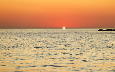 Image showing Sunset, ocean and horizon with a view over the sea during summer under an orange sky for mockup. Nature, water and earth with waves on a seascape for zen, peace or inspiration on a sunrise backdrop