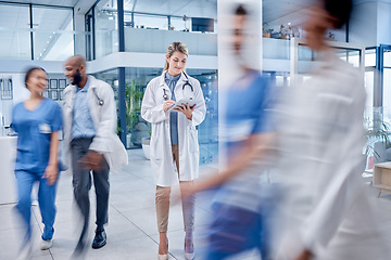 Image showing Busy, woman and doctor with tablet, typing and hospital for help, online reading and consultation. Medical professional, female and lady with device, lobby and connection to search website and medic