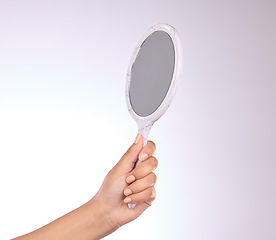 Image showing Hand, mirror and beauty with a person in studio on a gray background for a skincare examination. Product, luxury and reflection with a woman holding a tool to apply makeup or cosmetics for wellness