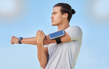 Image showing Fitness, health and man stretching arm for cardio exercise, running and marathon training with body healthcare goals. Sky, freedom and calm with athlete warm up in outdoor for performance workout