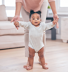 Image showing Black baby portrait, walking and learning with mother in a living room lounge with mobility development. Floor, home and first steps of a young kid with mama help with love, care and support in house