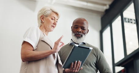 Image showing Business people, tablet and conversation working on report, reading communication or planning startup leadership strategy. Senior man, woman and discussion standing in lobby on digital tech device