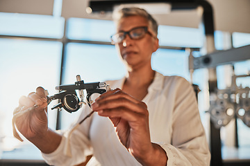 Image showing Trial frame, optometry and hands of woman in hospital or clinic for optician eye test. Vision, healthcare and senior female doctor or ophthalmologist holding equipment for examination of eyesight.