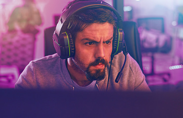 Image showing Serious video game, man and esports to play online games, virtual competition and face in dark room. Gamer guy, gaming and night on headset in neon lighting, technology and digital computer streamer