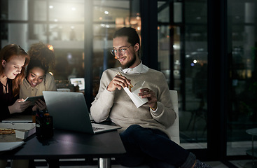 Image showing Night business, man and eating noodles in office for laptop, planning or research in startup. Young employee, fast food and computer overtime in dark agency with happy team, productivity or deadlines