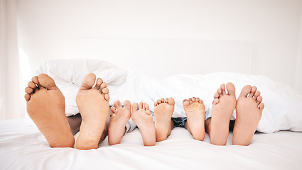 Image showing Family feet, bedroom and bed in the morning of a mother, father and young children sleeping. Mama, kids and dad foot in a house feeling relax and rest from sleep on vacation together with bonding