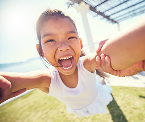 Image showing Girl child, pov spin and happy portrait with speed, smile and ocean park in summer sunshine with happiness. Young female kid, swing and playing outdoor with fast movement, holding hands and freedom