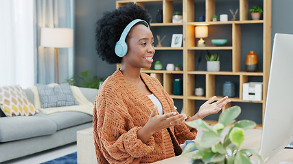 Image showing Call center agent talking and helping customers while wearing a headset and working on a desktop computer at home. Happy and cheerful black woman working in sales and networking with clients online