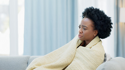 Image showing Woman sick with the flu on a couch at home, sneezing and blowing her nose. Young female suffering from sinus, allergies or covid19 while isolating. Lady taking off from work to recover from a cold